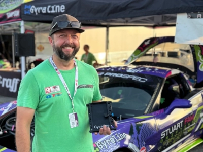 Race driver using Gyraline near a track car